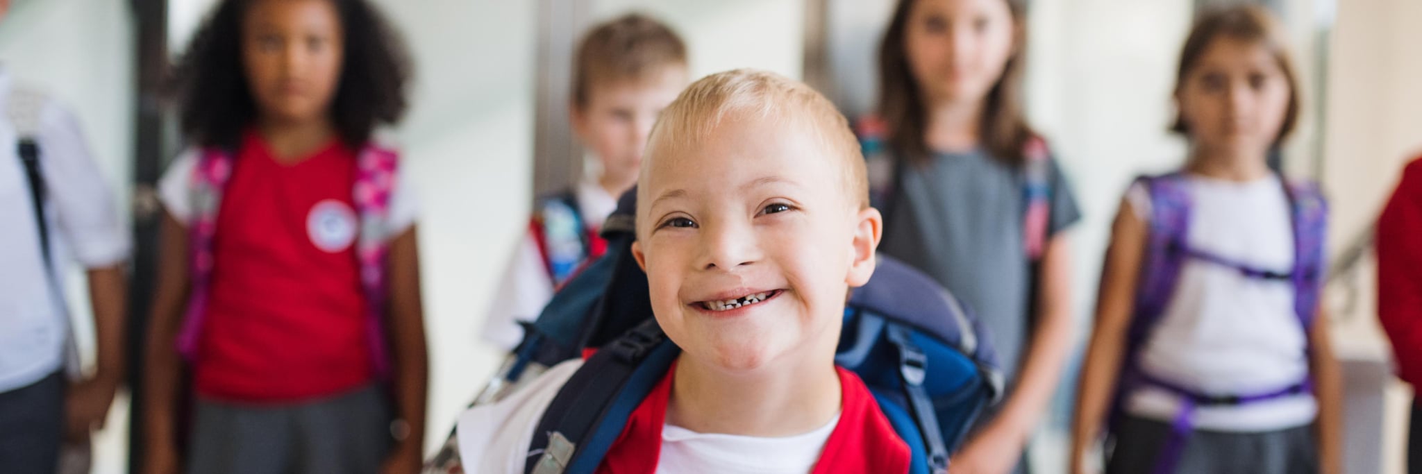 A special needs student smiling in front of other classmates